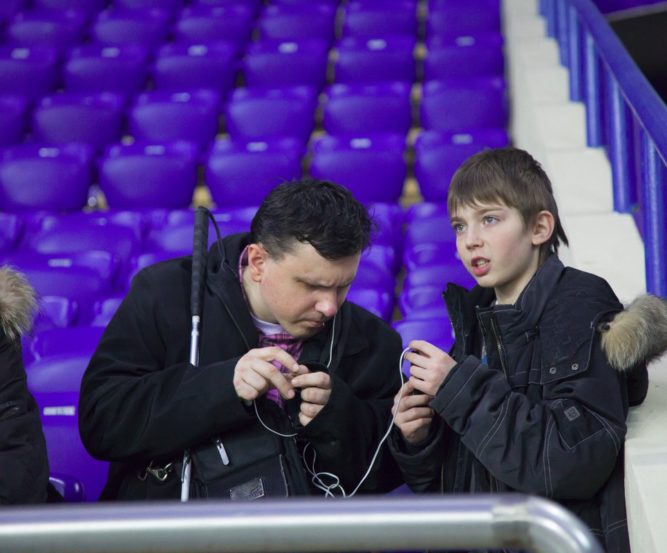 Une personne aveugle profite d'un match de football